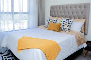 a bedroom with a bed with a yellow blanket on it at Royal Golfview Stay in Boksburg