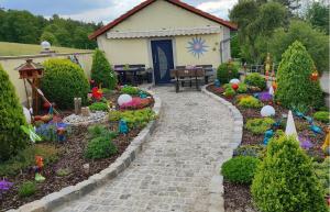 a garden with a house with flowers and a pathway at Ferienwohnung Kunz in Schönbrunn