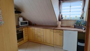 a kitchen with wooden cabinets and a white refrigerator at Ferienwohnung Kunz in Schönbrunn +11 photos