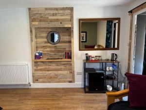 a room with a wooden wall with a mirror at Ardenbeg in Grantown on Spey