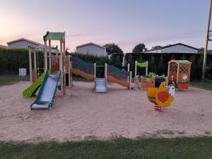 a playground with a slide at Mobil home camping les Charmettes 4 étoiles les MATHES en Charente Maritime prés du ZOO de la Palmyre 8 personnes tout confort 3 chambres 2salles de bains 2 WC Lave linge lave vaisselle Climatisation bien situé in Les Mathes