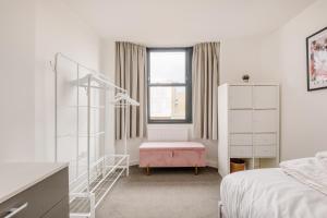 Un dormitorio blanco con una cama y una silla. en Modern Hove Home close to Brighton Beach with FREE PARKING, en Brighton & Hove