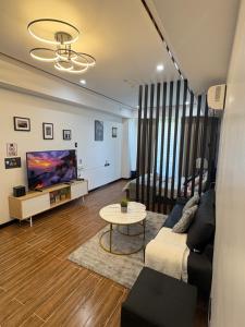 a living room with a couch and a tv at Sybaysuites staycation near Okada COD MOA NAIA airport Solaire in Manila
