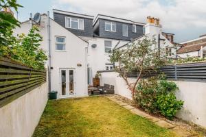 una vista exterior de una casa blanca con patio en Modern Hove Home close to Brighton Beach with FREE PARKING, en Brighton & Hove