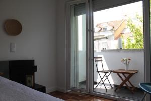 リスボンにあるNew Graça Spacious Apartmentのベッドルーム1室(バルコニーへ続くガラスのスライドドア付)