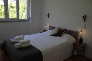 リスボンにあるNew Graça Spacious Apartmentのベッドルーム1室(白いベッド1台、タオル付)