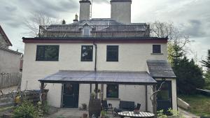 a large white house with a balcony on top of it at Ardenbeg in Grantown on Spey