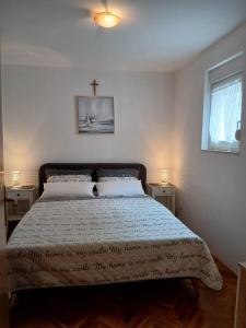 una camera da letto con un letto con una croce sul muro di Apartment Emily a Omiš (Almissa)