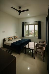 a bedroom with a bed and a table and a window at Sky Club Bir Hospitality in Bīr +10 photos