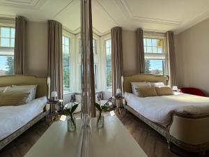 een slaapkamer met twee bedden en een grote spiegel bij B&B Villa Frisia in Steenwijk