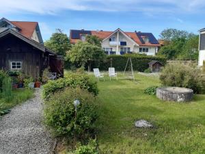 two white chairs sitting in the yard of a house at Haus Mayer in Weilheim in Oberbayern