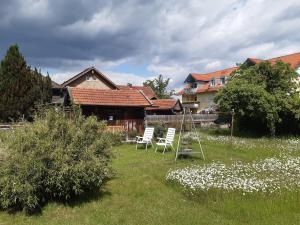 a yard with two white chairs and a house at Haus Mayer in Weilheim in Oberbayern