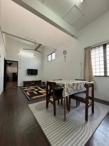 Una sala de estar con una mesa y una alfombra. en Rumah Bonda, en Gua Sai
