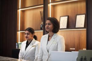 two women in white suits standing in a room at Moon Hotel in George Town