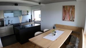 a kitchen with a wooden table and a dining room at Casa Seeblick in Hagnau
