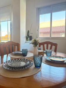 a table with plates and bowls on top of it at Apartamento Altamar Portonovo, 100 m playa in Sanxenxo