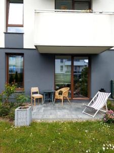 a patio with two chairs and a table in front of a house at Meta nad morzem in Pogórze