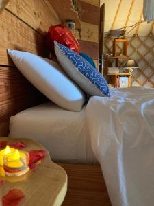 a pile of pillows sitting on top of a bed at Yourte moderne, tout confort in Vouzan