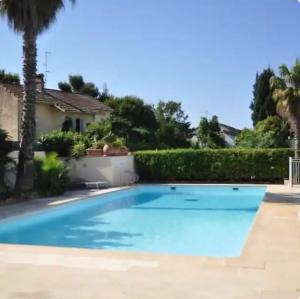 a swimming pool in front of a house at Mandelieubeach06 in Mandelieu-La Napoule