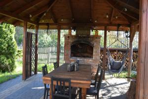 a patio with a wooden table and a fireplace at Apartament Loft na Kaszubach - Laskowa Góra Bieszkowice in Bieszkowice