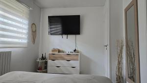 a bedroom with a flat screen tv on a white wall at Mandelieubeach06 in Mandelieu-La Napoule