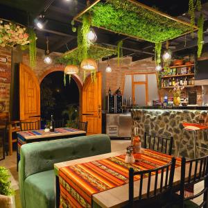 a restaurant with tables and chairs and ivy on the ceiling at Molino de Café Cabañas Lodge in Chinchín Loma