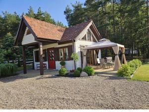 a small white house with a gazebo at Domek pod sosnowym lasem in Borowy Młyn