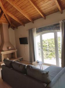 a living room with a couch and a large window at Ανέμη in Panayía