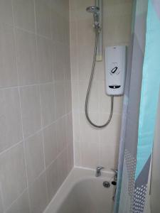 a bathroom with a shower and a bath tub at Pokój 1osobowy in Moffat