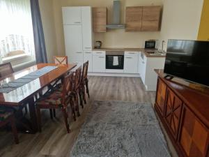 a kitchen with a dining room table and a television at Villa Donaublick in Kleinpöchlarn