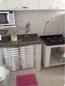 une cuisine avec un évier et un micro-ondes dans l'établissement Vanderli - Deli, à São Vicente