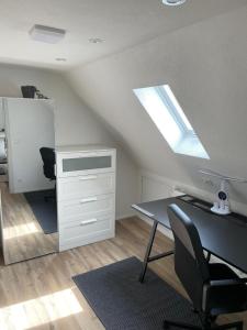 an attic office with a desk and a skylight at Moderne Ferienwohnung Horb-Altheim in Horb am Neckar +8 photos