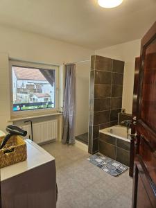 a bathroom with a shower and a tub and a sink at Gästehaus Schindhard in Schindhard +23 photos