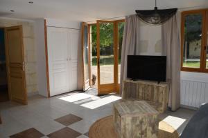 a living room with a flat screen tv on a stand at Zélie Gîte in Ambillou-Château