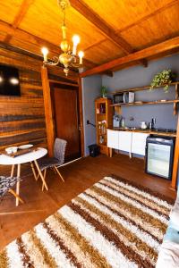 a living room with a table and a rug at Chale do Mirante in Blumenau +11 photos