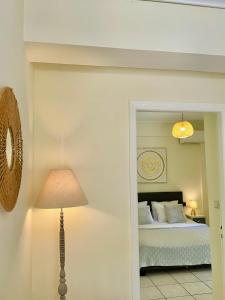 a bedroom with a bed and a lamp and a mirror at Sophilia Garden escape in Patra