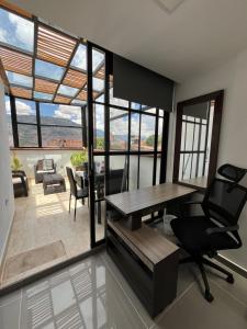 a dining room with a table and chairs and windows at nuevo amanecer in Bello