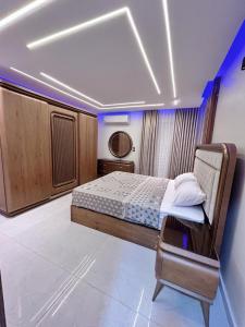 a bedroom with a bed and a chair in a room at Comfy 3 Bedrooms Apartment in Cairo Sheraton Airport in Cairo