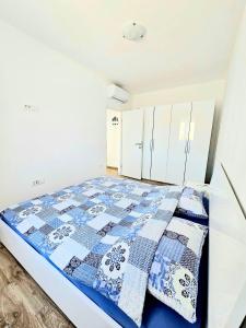 a bedroom with a bed with a blue and white quilt at Bepo in Zadar