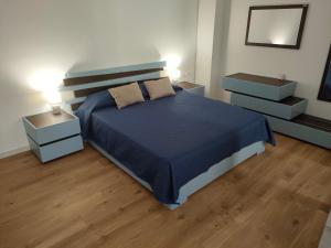 a bedroom with a blue bed and two night stands at DH Studio Apartments in Castellammare del Golfo
