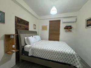 a bedroom with a bed with a white comforter at VSS Rustic in Arecibo - Stylish & Relaxing Escape Near Beaches in Arecibo