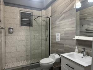 a bathroom with a shower and a toilet and a sink at VSS Rustic in Arecibo - Stylish & Relaxing Escape Near Beaches in Arecibo +18 photos