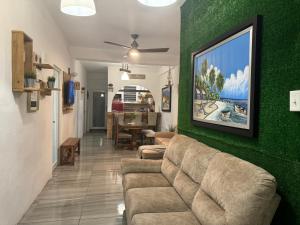 a living room with a couch and a green wall at VSS Rustic in Arecibo - Stylish & Relaxing Escape Near Beaches in Arecibo