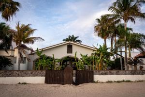 瓜伊马斯Casa Recuerdos的棕榈树海滩上的房子