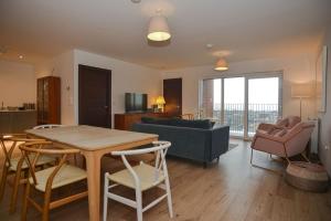 a living room with a table and a couch at Seaview City Lodge , 2- bedroom flat with Parking in Southend-on-Sea