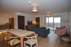 a living room with a table and a couch at Seaview City Lodge , 2- bedroom flat with Parking in Southend-on-Sea