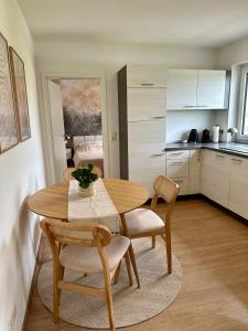 een keuken en eetkamer met een houten tafel en stoelen bij Mosel Solea Boutique Apartment in Klüsserath