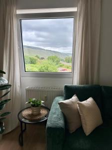 een woonkamer met een groene bank en een raam bij Mosel Solea Boutique Apartment in Klüsserath