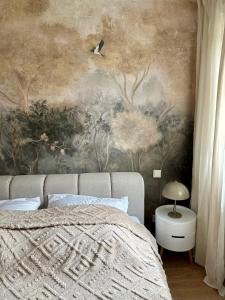 een slaapkamer met een schilderij aan de muur bij Mosel Solea Boutique Apartment in Klüsserath