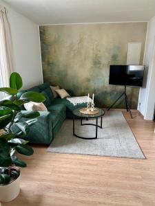 een woonkamer met een groene bank en een tafel bij Mosel Solea Boutique Apartment in Klüsserath